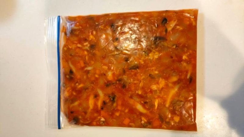 冷凍鯖のトマト煮込みをジップロックに入れて冷凍保存している様子