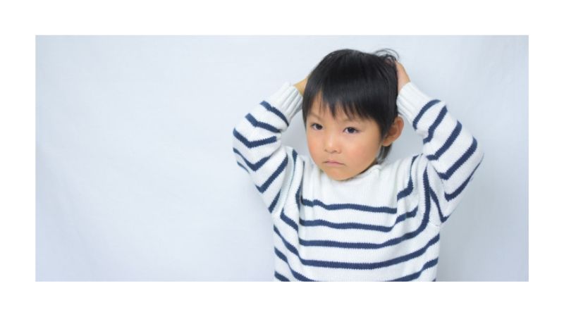 頭を抱えて悩むこども